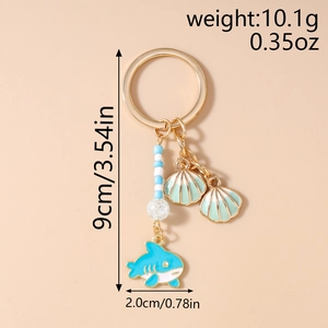Detail view of a 9cm ocean themed shark keychain with beads and mint green shells