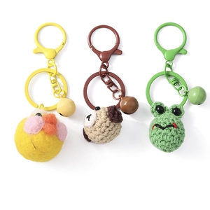 Handmade knitted animal keychains featuring yellow bird, brown dog, and green frog pendants