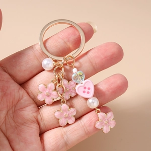 Detailed shot of a floral keychain with cherry blossom charms and pink heart beads