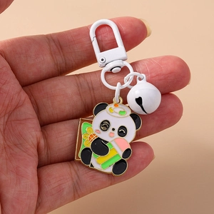 Détail d'un porte-clés panda avec clochette blanche et fermoir mousqueton en main