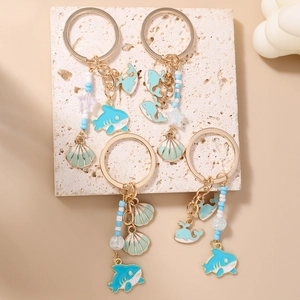 Blue tassel ocean themed keychains with shark shell pendants on a stone surface