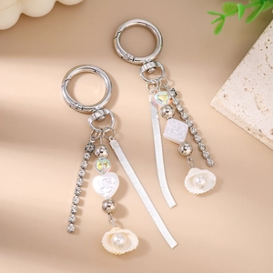 Detail of silver tassel keychain with rhinestones, shell pendant, and pearl beads