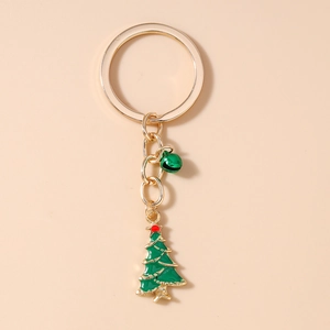 Détail d'un porte-clés sapin de Noël avec anneau doré et pendentif cloche verte