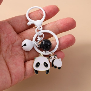 Détail d'un porte-clés panda en métal avec breloques mignonnes et grelots décoratifs