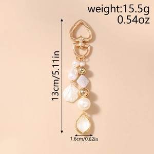Détail de porte-clés perles avec charme coquillage mesurant 13cm de haut et 1,6cm de large