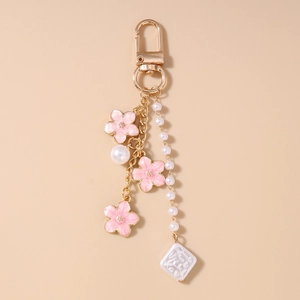 Detail der Kirschblüten-Schlüsselanhänger mit Gold-Finish und eleganten weißen Perlen