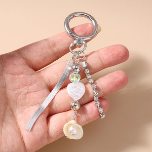 Detail of keychain featuring tassel, shell, pearl heart beads, and rhinestone chain charm