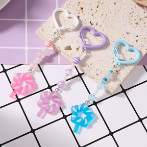 Colorful tassel beaded keychain with heart carabiner and candy charm on stone surface