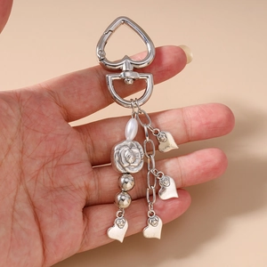 Detail of silver heart keychain with embossed rose beads and hanging pearl charms