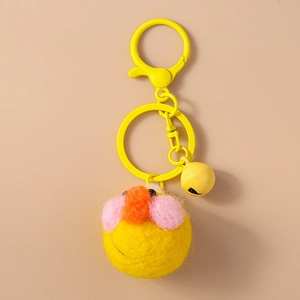Detailed macro of yellow plush duck keychain with pink cheeks and metal bell attachment