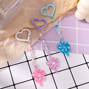 Detailed close-up of pink, purple, and blue beaded keychains with resin candy pendants