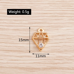 Detail of geometric diamond-shaped gold pendant with rhinestone and size measurements