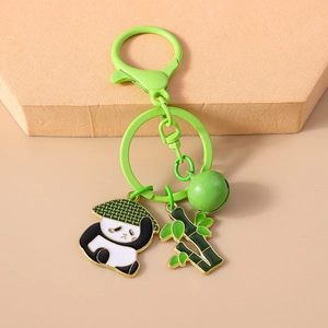 Gros plan d'un porte-clés panda avec breloque bambou et clochette verte sur crochet