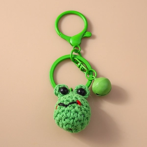 Close-up of green knitted frog keychain with metal spring clasp and matching bell charm
