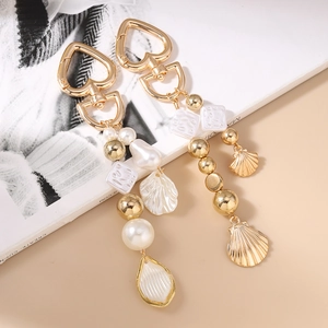 Porte-clés doré avec perles, coquillages et perles de pierre sur un fond de magazine