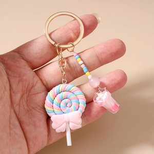 Close-up of a sweet lollipop keychain with macaron beads and gold metal ring