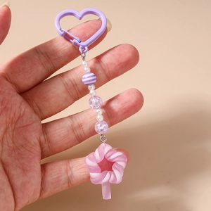 Detail of beaded keychain with purple heart clasp and pink swirl lollipop charm