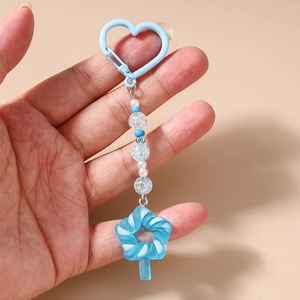 Detail of blue beaded keychain with heart clasp and blue white spiral candy pendant