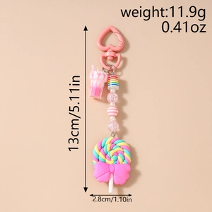 Detail view of colorful clay lollipop keychain with pink bow and heart buckle