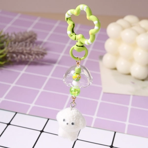 Detail der Perlenkette mit grünem Blumenclip und weißem Plüsch-Hundeanhänger