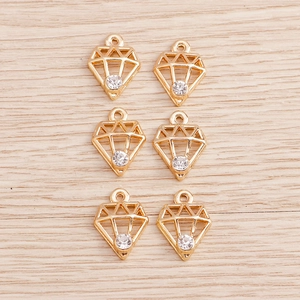 Detail of geometric diamond-shaped gold pendants with inlaid rhinestones for DIY jewelry