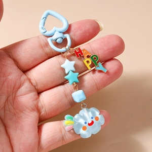 Détail d'un porte-clés pastel avec clip cœur bleu, breloque HAPPY et nuage souriant