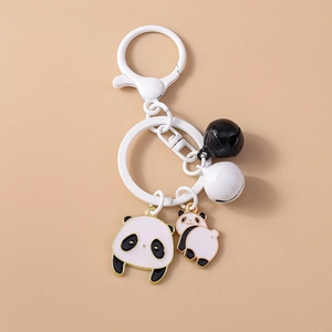 Détail du porte-clés panda avec breloques en émail, cloches et fermoir mousqueton blanc