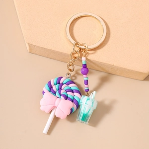 Detail of sweet lollipop keychain with beads and mini cold drink cup on a warm background