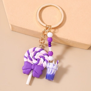 Detail shot of a candy-themed keychain with purple lollipop and golden clasp hooks