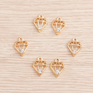 Detail of geometric diamond-shaped gold pendants with clear rhinestones for DIY jewelry