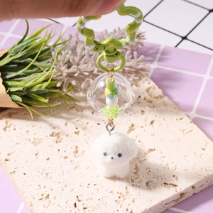 Detail eines Bichon Frisé Plüsch-Schlüsselanhängers mit grüner Blume und bunter Perlenkette