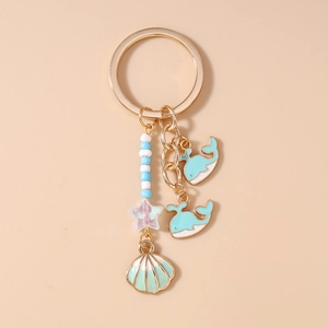 Detailed view of ocean theme keychain with blue dolphin charms and seashell tassel