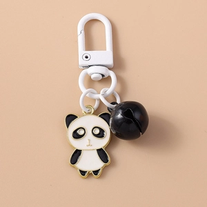 Porte-clés panda mignon avec clochette noire et détails dorés sur un fond crème neutre