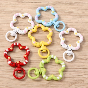Five creative spotted floral spring keychains in assorted colors on wooden background