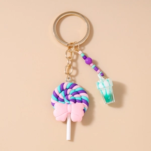 Detail of colorful beads and lollipop charm with blue resin cup on a gold keychain
