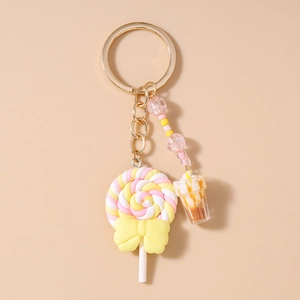Macro detail of lollipop keychain with pink beads, bow and mini coffee cup charm