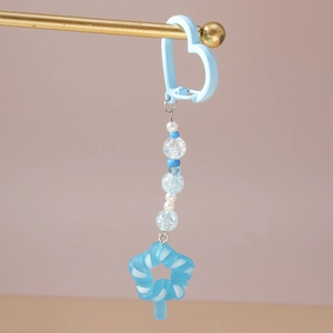 Detail of blue beaded keychain featuring a star lollipop pendant and heart-shaped hook