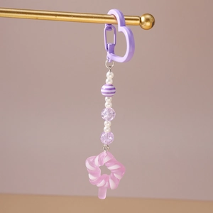 Detail of beaded keychain with purple heart clasp and pink swirl lollipop charm