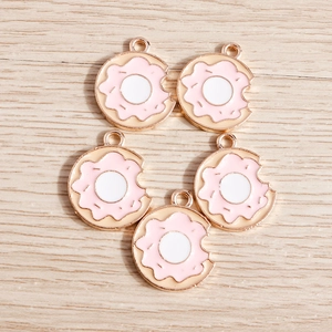Detail view of five pink doughnut charms with bite marks for DIY jewelry making