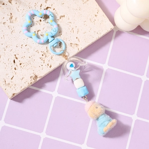 Detail der Perlenkette mit blauen Quallen-Perlen und Plüsch-Teddybär im blauen Pullover