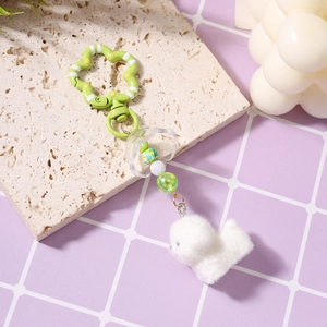 Detail der Perlenkette mit grünem Blumenhaken und niedlichem weißen Plüsch-Hund-Anhänger