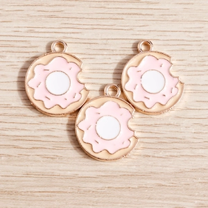 Macro shot of three pink and white donut charms with bite details for DIY jewelry