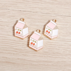 Detail of pink and white enamel milk carton charms with cherry motif for jewelry DIY