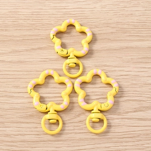 Close-up of yellow floral lobster clasps with pink dots for DIY jewelry making