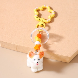 Detail eines Plüsch-Corgi-Schlüsselanhängers mit Perlen und blumenförmigem Clip