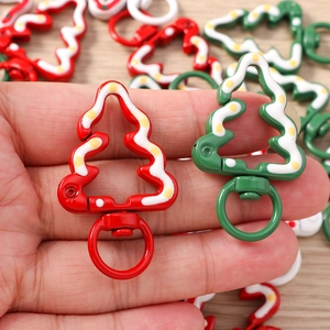 Close-up of red and green Christmas tree lobster clasps with festive snow dot patterns
