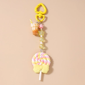 Detail of colorful polymer clay lollipop keychain with striped beads and caramel tea cup