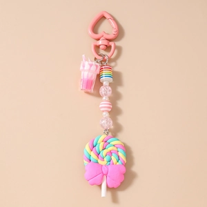 Detail of macaron keychain with rainbow beads, pink heart clip and swirl lollipop