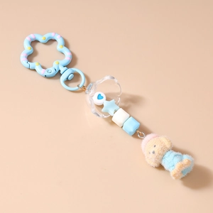 Detailansicht eines blauen Teddybär-Plüsch-Schlüsselanhängers mit Perlen und Blumenclip