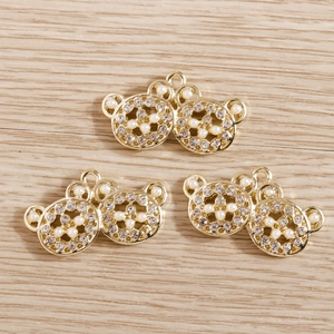 Detail view of golden bear jewelry pendants with white pearls and sparkling rhinestones